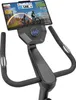Close-up of the handlebars and console of an exercise bike with a tablet mounted. Produktbild-Vorschau