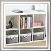 A white cube shelf unit filled with books and storage bins. Anteprima dell’immagine prodotto