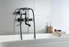 A black retro-style bathtub faucet with a handheld showerhead is mounted on a tiled wall above a white bathtub. Anteprima dell’immagine prodotto