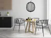 A dining area in a modern kitchen with a round wooden table and black chairs. Produktbild-Vorschau