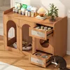 A wooden cat furniture piece with two enclosed spaces, drawers, and a cat eating from a bowl. Produktbild-Vorschau