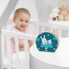 A baby is in a crib, and a night light is on a table next to it. Voir les images du produit
