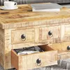 A close-up view of a wooden coffee table with drawers, showing a cup of coffee and books on top. Produktbild-Vorschau