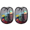 Two black mesh laundry baskets filled with colorful clothes and a stuffed carrot toy. Produktbild-Vorschau