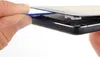 A hand is using a blue plastic tool to pry open a smartphone. Produktbild-Vorschau