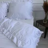 A white duvet cover and pillowcase with ruffles are laid out on a bed. Podgląd zdjęcia produktu