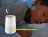 A young child sleeping next to a white device on a bed. Podgląd zdjęcia produktu