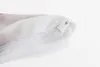 A close-up view of a white zipper closure on a piece of fabric, with a hint of red pattern visible. Produktbild-Vorschau