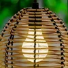 Close-up of a rattan-style pendant lamp with a light bulb inside. Anteprima dell’immagine prodotto