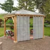 A gazebo with curtains on a paved patio in a garden setting. Anteprima dell’immagine prodotto
