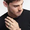 A man wearing a black t-shirt is shown wearing a ring on his left hand. Voir les images du produit