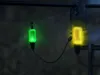 Two fishing bite indicators, one green and one yellow, are attached to a fishing line in the dark. Produktbild-Vorschau