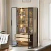 A tall, open display cabinet with shelves and drawers, filled with books, trophies, and decorative items. The cabinet is illuminated by internal LED lights and is situated in a well-lit room with a sofa visible in the foreground. Anteprima dell’immagine prodotto