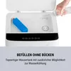 Close-up of the top of a white appliance, with a blue ice pack and water being poured from a bottle. Produktbild-Vorschau