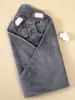 A gray hooded towel with an elephant face design is folded and laid flat on a light beige surface. Produktbild-Vorschau
