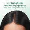 Close-up of a person's dark hair and scalp, with text overlay. Produktbild-Vorschau
