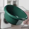 A green plastic bowl is shown in a laundry room setting, with a washing machine visible in the background. Podgląd zdjęcia produktu