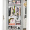 An organized closet with clothes hanging on a rack and storage boxes on shelves. Anteprima dell’immagine prodotto