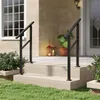 A black metal handrail is installed on a set of outdoor stairs leading to a house entrance. Podgląd zdjęcia produktu