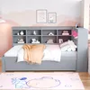 A child's bedroom with a grey daybed, bookshelf headboard, and a pink rug with cartoon characters. Produktbild-Vorschau