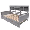 A gray wooden daybed with a built-in shelf unit at the headboard, shown from a three-quarter angle against a white background. Náhled obrázku produktu