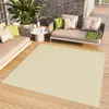An outdoor patio setting with furniture and a rug.
