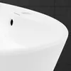 A close-up view of a white ceramic sink with a dark tiled background. Náhľad obrázku produktu