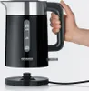 A hand holding a black electric kettle over its power base. Produktbild-Vorschau