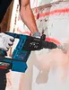 A person is using a Bosch rotary hammer to drill into a concrete wall. The wall has red markings on it. Produktbild-Vorschau