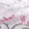 A close-up view of a white sheer curtain with a floral pattern and text overlay. Produktbild-Vorschau