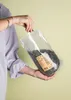 A person holding a bag of roasted and salted pumpkin seeds. Produktbild-Vorschau