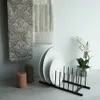 Kitchen scene with decorative towels, plates in a drying rack, and candles. Produktbild-Vorschau