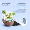 A coconut cut in half, with a tropical island scene inside, surrounded by black granular material, with text callouts describing product features. Voir les images du produit