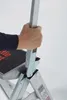 A hand is shown gripping a metal handle on a step ladder. Podgląd zdjęcia produktu