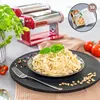 A pasta maker and a plate of freshly made pasta are displayed. Produktbild-Vorschau