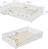 Two views of a white wooden children's bed with cut-out star and moon designs on the side panels, showing dimensions. Produktbild-Vorschau