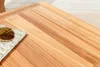 A close-up view of a wooden table surface with a pair of sunglasses resting on a folded cloth. Produktbild-Vorschau