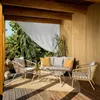 A patio furniture set on a wooden deck, with trees and foliage visible in the background. Náhľad obrázku produktu