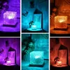 A collage of images showing a cube-shaped lamp with textured surfaces, illuminated in different colors. Anteprima dell’immagine prodotto