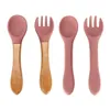 Four baby utensils, two spoons and two forks, are arranged in a row against a white background. Two of the utensils have wooden handles, while the other two have silicone handles. Voir les images du produit