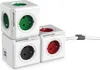 Three white power cubes are stacked and arranged in a cluster, with one cube on the bottom left featuring two USB ports. The cubes have different colored sockets: green on the top cube, red on the middle right cube, and black on the bottom left cube. A whi Náhled obrázku produktu