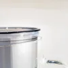 A close-up view of the lid and top of a clear glass pitcher with a silver insert. Produktbild-Vorschau