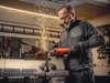 A man is using an angle grinder in a workshop. Podgląd zdjęcia produktu