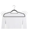 A gray velvet hanger holding a white long-sleeved shirt against a white background. Produktbild-Vorschau