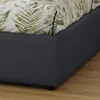 A close-up view of the corner of a bed frame with a floral duvet. Produktbild-Vorschau