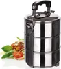 A stainless steel food carrier with three tiers, next to a plate of spaghetti and a tomato. Produktbild-Vorschau