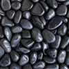 Schwarze Kieselsteine mit glänzender Oberflächenstruktur dicht nebeneinander im Detail Produktbild-Vorschau
