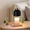 A candle warmer lamp with a candle, a small plant, and an hourglass on a wooden table. Náhled obrázku produktu