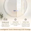 A close-up of a round LED bathroom mirror with touch controls and a digital display showing time and temperature. The mirror is partially reflecting blinds. Anteprima dell’immagine prodotto