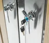 A close-up of two metal handles on a metallic surface, with keys attached to one of the handles. Náhled obrázku produktu